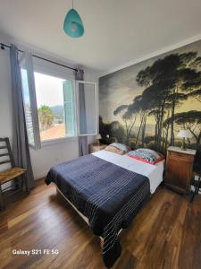 アジャクシオにあるT3 Ajaccio vue merのベッドルーム1室(壁に絵画が描かれたベッド1台付)