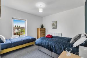 sypialnia z 2 łóżkami i oknem w obiekcie Silver Stag Properties, Newly Renovated 2 BR House w mieście Church Gresley