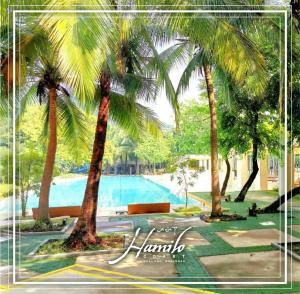 a group of palm trees next to a swimming pool at Pico De Loro 2BR Carola B Unit with Lagoon View in Nasugbu