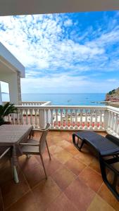 een balkon met een tafel en stoelen en de oceaan bij Apartmani Lukšić in Sutomore