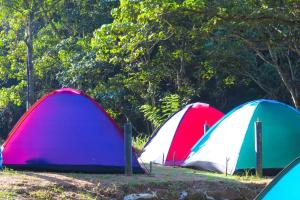 a group of three tents parked in a field at Bambara Ella Agro Resort & Camping in Haputale