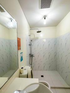 een badkamer met een wastafel, een toilet en een douche bij Pico de Loro Cove Hamilo Coast, Apartment 519, Corner Studio Unit, Jacana B Condominium in Nasugbu