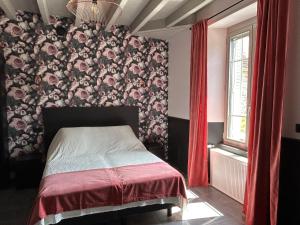 a bedroom with a bed with a floral wall at Gite La Fileuse in Saint-Plantaire