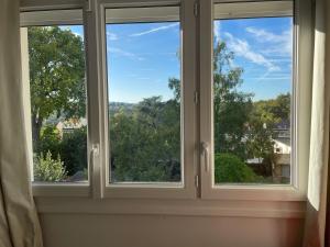 a window with three views of the sky at SGDB in Sainte-Geneviève-des-Bois