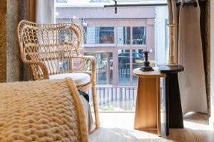 a bedroom with a wicker chair and a window at Host Inn - Duplex Insolite & Chic - Ancienne librairie in Lyon