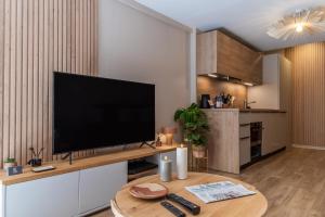 a living room with a flat screen tv on a table at Host Inn - Duplex Insolite & Chic - Ancienne librairie in Lyon