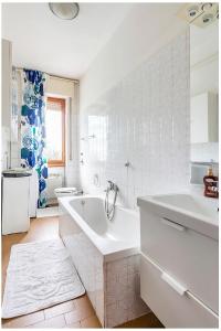 un bagno bianco con vasca e lavandino di Appartamento Milano a Milano