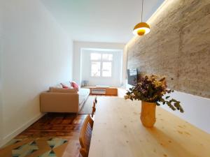 a living room with a table and a brick wall at VibesCoruña- Apartamento céntrico recién reformado in A Coruña