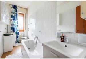 un bagno bianco con lavandino e vasca di Appartamento Milano a Milano