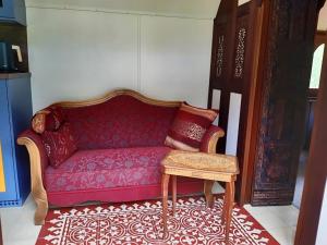 a red couch with a stool in a room at Zigappo Orientale in Lychen