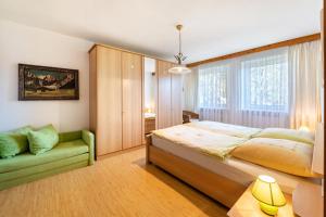 1 dormitorio con 1 cama grande y 1 sofá verde en Ferienwohnung im Haus Stöckl, en Angerberg