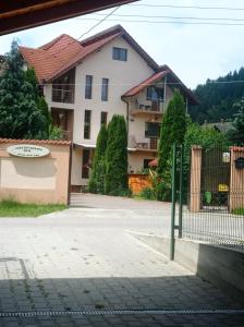 a white house with a fence and a building at Casa de Vacanta Eva in Stoeneşti