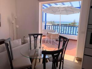 a living room with a glass table and a view of the ocean at CASA del CHARCO 2,1 in Arrecife
