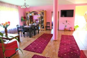 a pink living room with a table and a pink pole at Casa de Vacanta Eva in Stoeneşti