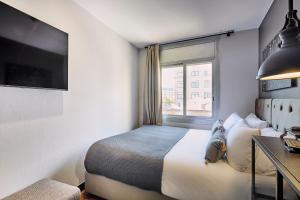 a hotel room with a bed and a window at Hotel Cortes Rambla in Barcelona