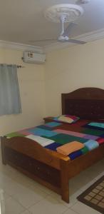 a bedroom with a bed with a colorful comforter at The bb's in Brusubi