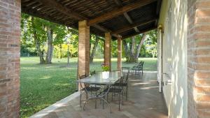 a patio with a table and chairs under a pavilion at La casetta nel bosco in Mantova