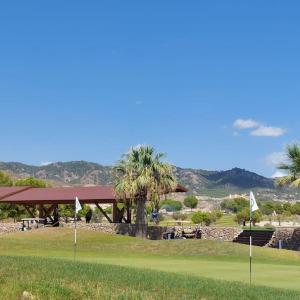 un campo de golf con palmeras y un pabellón en Apartamento con jardín en Altaona Golf en Murcia
