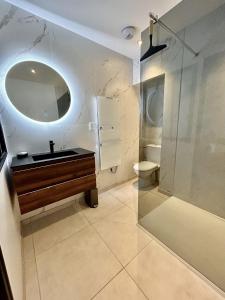 ein Bad mit einem Waschbecken, einer Dusche und einem Spiegel in der Unterkunft Chez Emile !- Appartement Atypique (Arras) in Arras