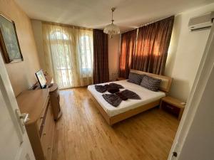 1 dormitorio con 1 cama, suelo de madera y ventanas en Славина къща, en Perushtitsa