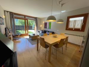 a kitchen and living room with a wooden table and chairs at B49 - Bajo con Jardín Peguera - Villmor in Benasque +34 photos