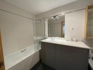 a bathroom with a sink and a tub and a mirror at B49 - Bajo con Jardín Peguera - Villmor in Benasque