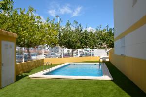uma piscina num quintal com relva verde em Kione Villamar em Alcossebre