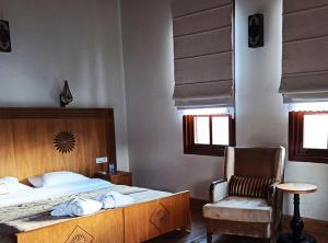 a bedroom with a large bed and a chair at Iksir Resort Town in Daday