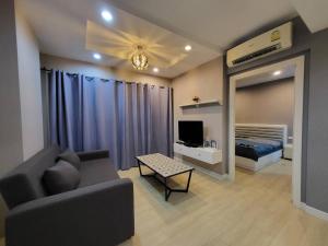 a living room with a couch and a bed at The patio condo Bang saen in Ban Bang Saen (1)