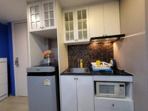 a small kitchen with a sink and a refrigerator at The patio condo Bang saen in Ban Bang Saen (1)