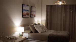 ein Schlafzimmer mit einem Bett und einem Tisch mit einer Lampe in der Unterkunft Apartamentos Hernán Cortés in Villanueva de la Serena