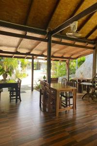 een eethoek met een houten tafel en stoelen bij Tann Anda Resort in Thalang