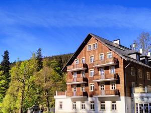 un gran edificio de ladrillo con techo negro en Horský apartmán Hubertus č.19, en Karlova Studánka