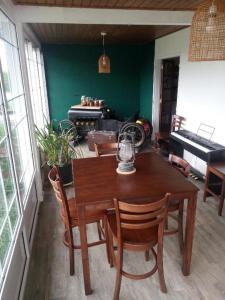 a dining room with a table and chairs and a piano at Ti'Kratèr Chambres et tables d'hôtes in Le Tampon