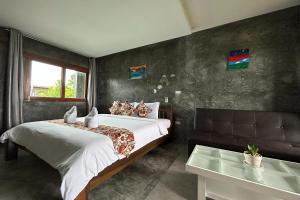 a bedroom with a bed and a table in it at Tann Anda Resort in Thalang