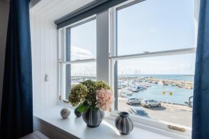 a window with vases of flowers on a window sill at Shorefront Apartment - Sea View with 3 Bedrooms in Anstruther