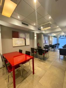 a dining room with a red table and chairs at SM Hotel Sant Antoni in Barcelona