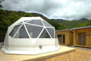 a large white tent sitting on top of a deck at dots by Dot Glamping Suite 001 in Fujikawaguchiko