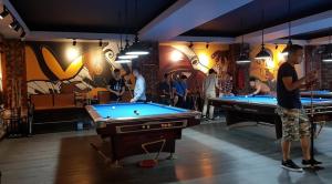 a group of people playing pool in a room at Kim Liên - Số 7 Đào Duy Anh - by Bay Luxury Hotel in Hanoi