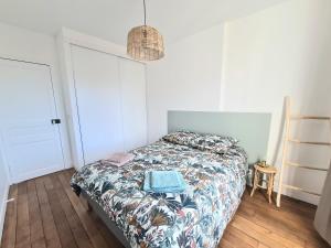 a bedroom with a bed with a comforter on it at Bel appartement F3 46m2 à 5' de Paris in Ivry-sur-Seine