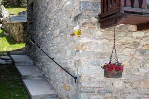 瓦爾圖爾嫩凱的住宿－HelloChalet - Chalet Grené typical house with garden - 1km cabelcar，盆里植有植物的石墙