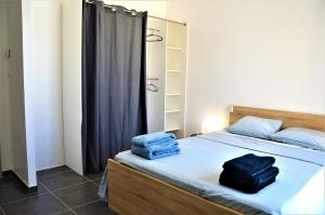 sypialnia z łóżkiem, na którym leżą dwa niebieskie ręczniki w obiekcie GITE CESAR 6p, 3ch, piscine privée, terrain privé clos, terrain de pétanque w mieście Vallon-Pont-dʼArc