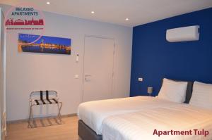 1 dormitorio con cama y pared azul en Relaxed Apartments Haarlem, en Haarlem