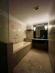 uma casa de banho com uma banheira, um lavatório e um espelho. em KLCC, Kuala Lumpur, Bukit Bintang at Times Square Hotel em Kuala Lumpur