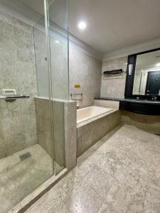 uma casa de banho com um chuveiro e uma banheira em KLCC, Kuala Lumpur, Bukit Bintang at Times Square Hotel em Kuala Lumpur