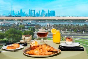 a table with pastries and coffee and a view of the city at Marriott Executive Apartments Dubai Creek in Dubai