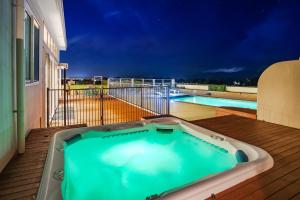 bañera de hidromasaje en una terraza junto a la piscina en Mountainview Villa Luxury Lodge & Glamping en Blenheim