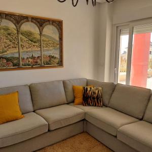 un sofá gris en una sala de estar con una pintura en Apartamento con jardín en Altaona Golf en Murcia