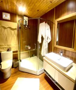 uma casa de banho com um chuveiro, um lavatório e um WC. em An Hoa Residence em Long Hai