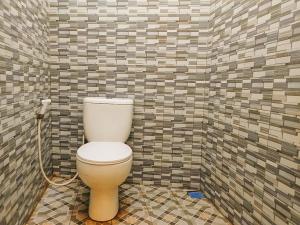 a bathroom with a toilet in a tiled wall at RedDoorz Syariah near Lippo Plaza Sidoarjo in Sidoarjo